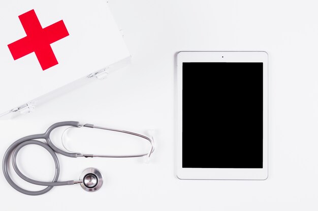 Trousse de premiers secours; stéthoscope et tablette numérique sur fond blanc