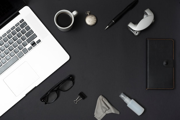 Trucs de bureau vue de dessus avec un ordinateur portable et une tasse de café sur un tableau noir