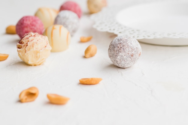 Truffes glacées colorées dispersées sur un tableau blanc