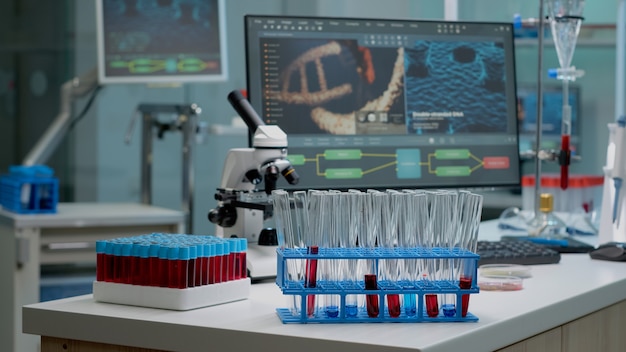 Photo gratuite tubes à essai médicaux avec du sang sur le bureau en laboratoire