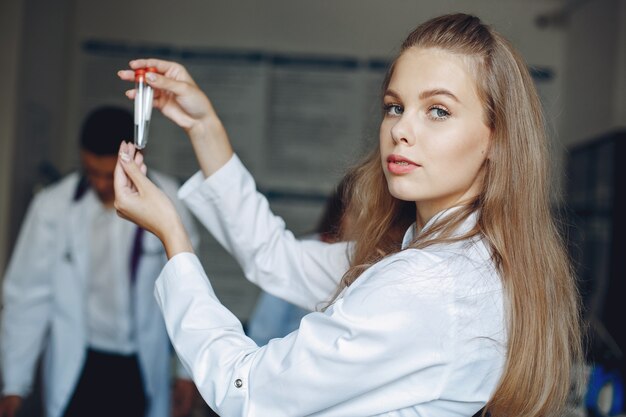 Étude sur les hommes et les femmes en blouse d'hôpital. Infirmière avec des tubes à essai.