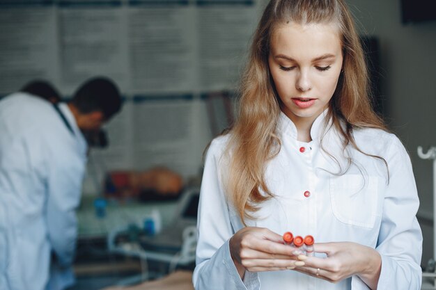 Étude sur les hommes et les femmes en blouse d'hôpital. Infirmière avec des tubes à essai.