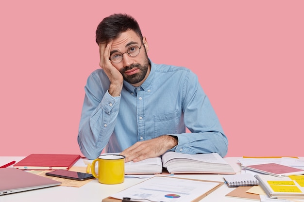 Étudiant assis au bureau avec des documents