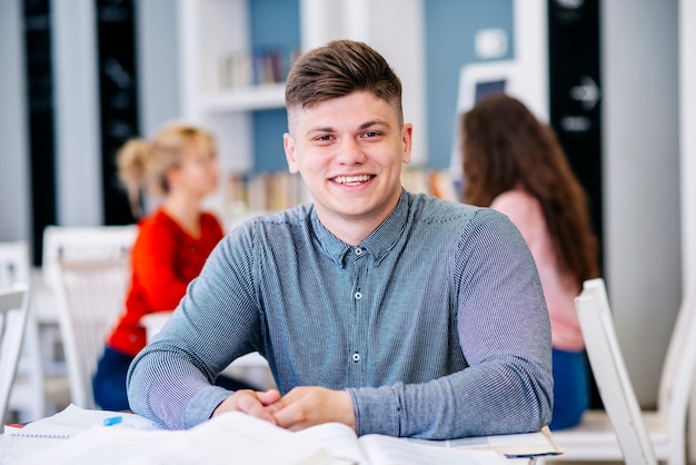 Étudiant assis à table dans la bibliothèque