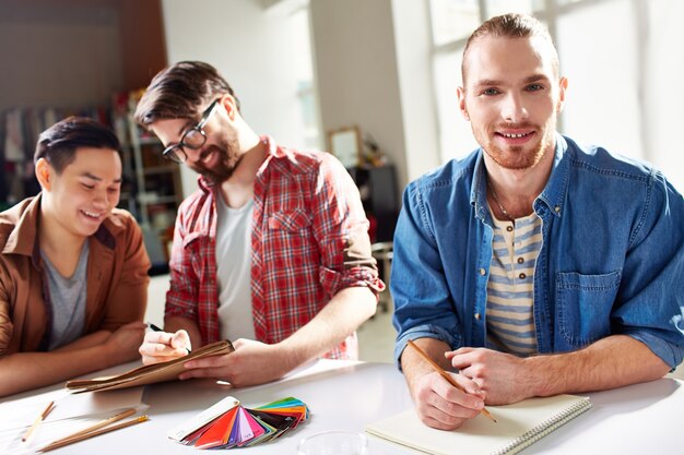 Étudiant avec la chemise bleue tenant un stylo