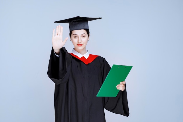 Étudiant diplômé avec diplôme gesticulant stop. photo de haute qualité