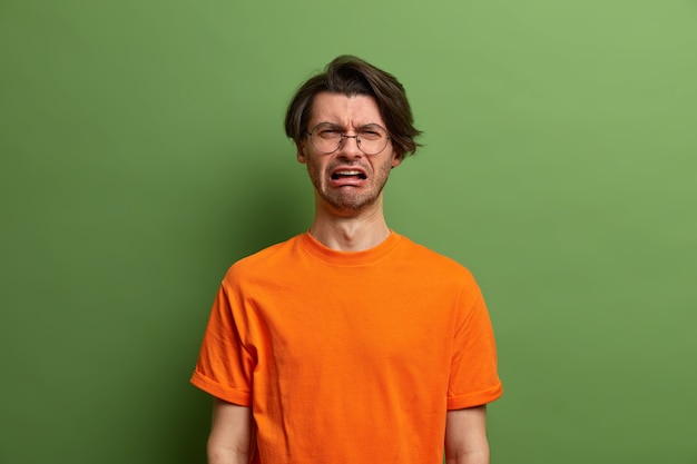 Étudiant de jeune bel homme avec la coiffure à la mode d'isolement