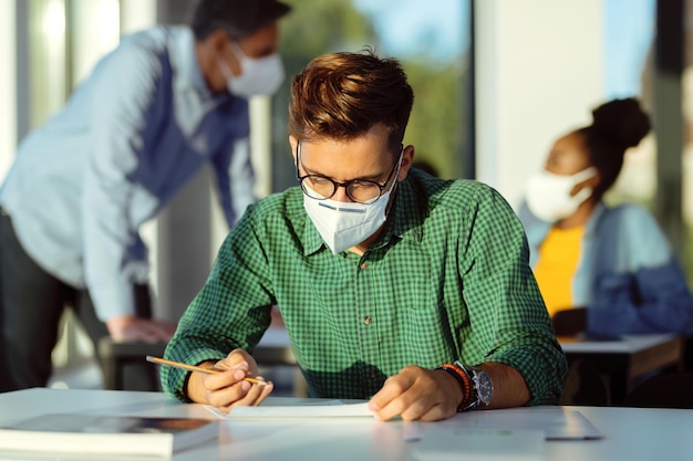 Étudiant portant un masque protecteur lors de l'examen en classe