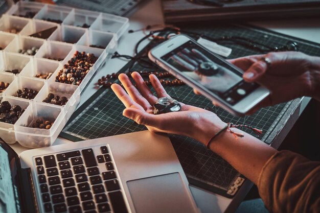 Étudiante créative faisant une photo de coquille via un smartphone alors qu'elle était assise sur son lieu de travail.