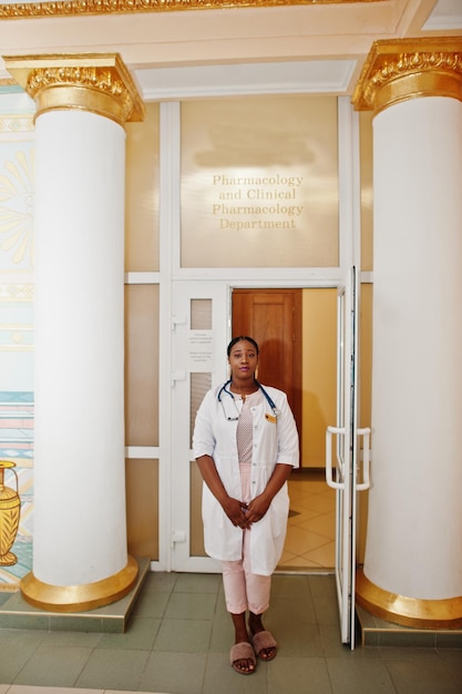 Étudiante en médecine afro-américaine en blouse de laboratoire avec stéthoscope à l'intérieur de l'université de médecine