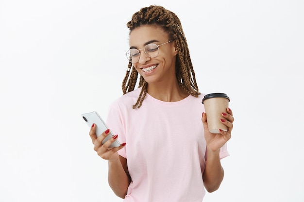 Étudiante moderne à la peau sombre et sociable communicative avec des dreadlocks en t-shirt rose