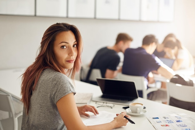 Étudiante travaillant sur un campus ou un café ou un espace de coworking étudiant la préparation de son diplôme sur un ordinateur portable