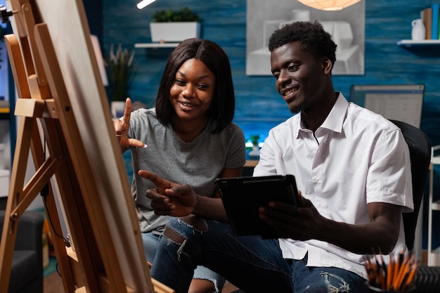 Étudiants en conception analysant un croquis de vase sur une tablette dessinant une illustration sur toile à l'aide d'un crayon graphique. Jeunes artistes étudiant pour une leçon d'art dessinant un chef-d'œuvre de peinture. Concept de peinture