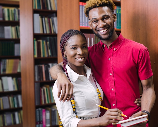 Étudiants noirs posant avec un bloc-notes