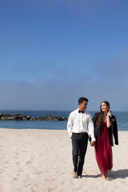 Étudiants en tenue de bal à la plage