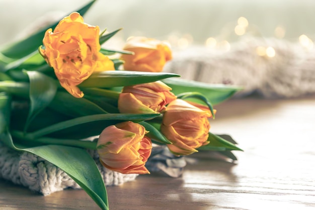 Photo gratuite des tulipes jaunes et un élément tricoté sur un fond flou