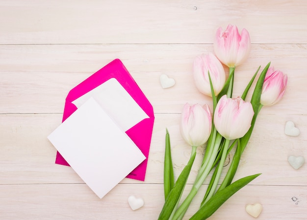 Photo gratuite tulipes avec papier vierge et enveloppe