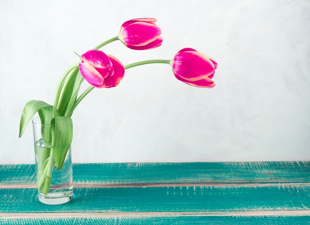 Tulipes roses dans un vase en verre sur table