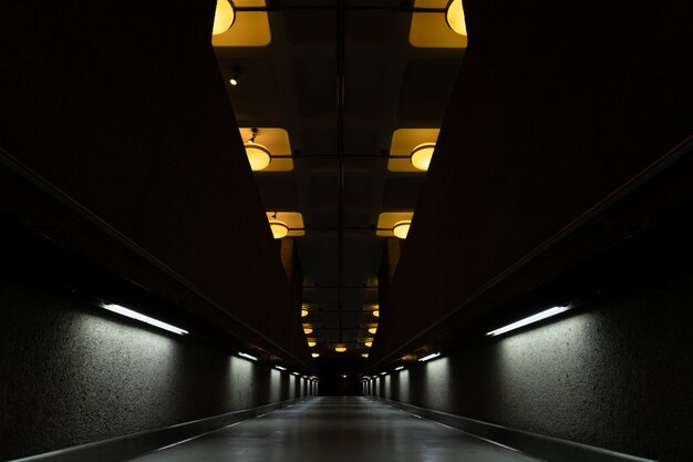 Tunnel sombre avec lampes allumées au plafond