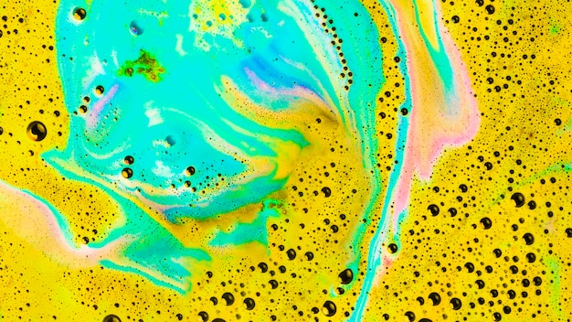 Photo gratuite turquoise et jaune dissolvent l'eau de la bombe du bain avec des bulles