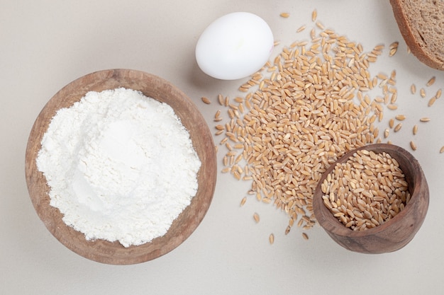 Œuf à la coque avec des grains d'avoine et un bol en bois plein de farine