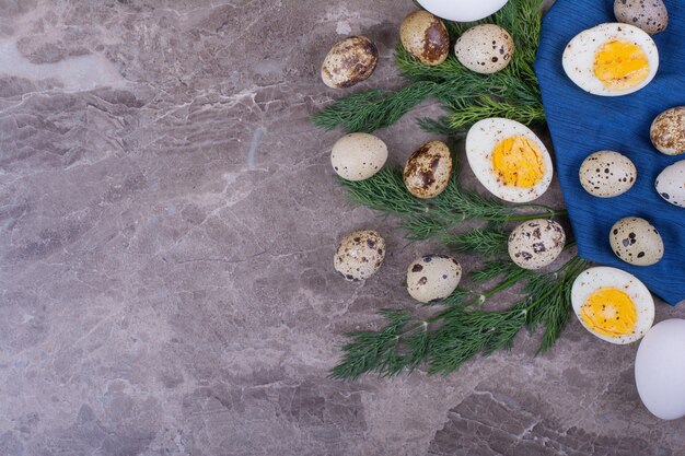 Œufs crus et durs aux herbes sur une serviette bleue