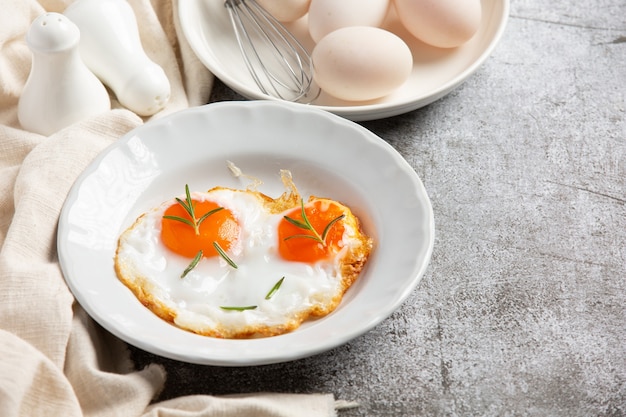 Œufs frits dans une assiette blanche