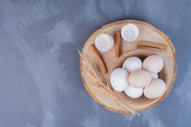 Œufs de poule aux coquilles d'œufs sur un plateau en bois