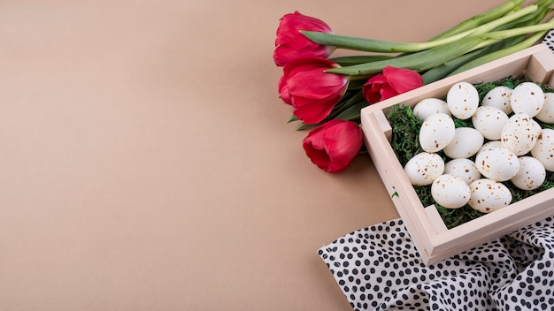 Œufs de poule blanche en boîte avec des tulipes