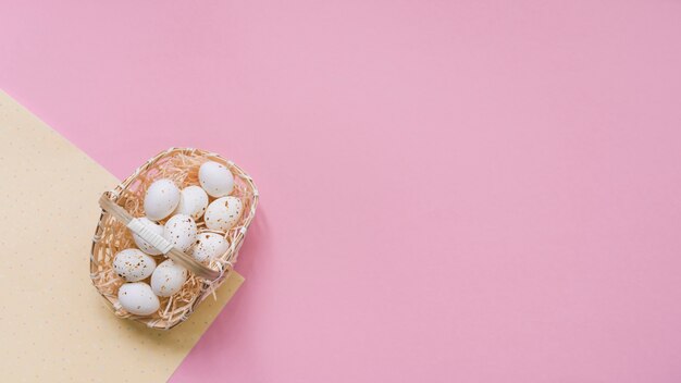 Œufs de poule blanche dans le panier sur la table rose