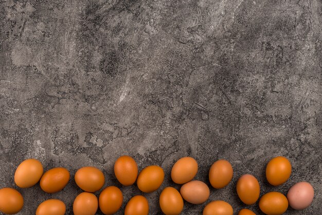 Œufs de poule brune dispersés sur une table grise