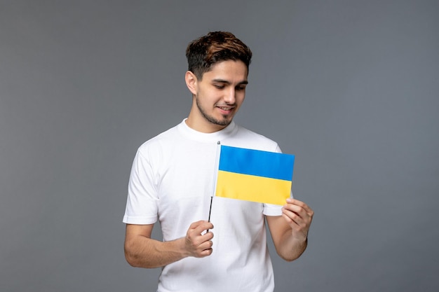 Ukraine conflit russe courageux mignon beau mec en chemise blanche avec regardant le drapeau ukrainien