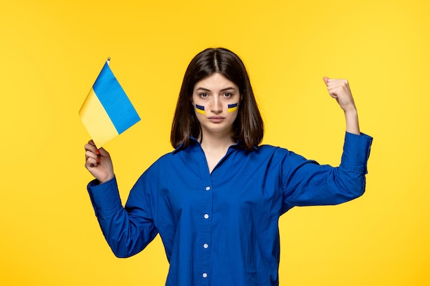 Ukraine conflit russe jeune jolie fille drapeaux sur les joues fond jaune montrant la force