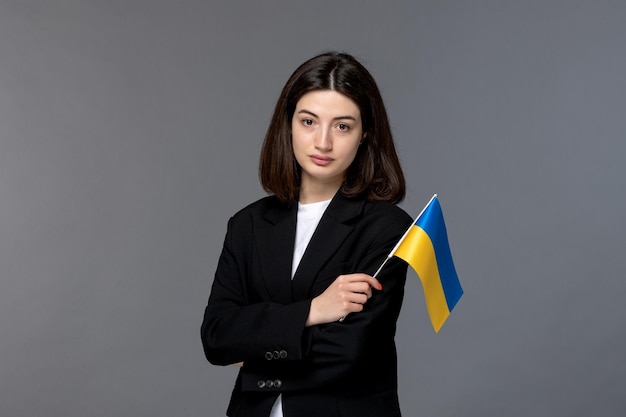 Ukraine conflit russe jolie jeune femme aux cheveux noirs en blazer noir visage sérieux avec drapeau