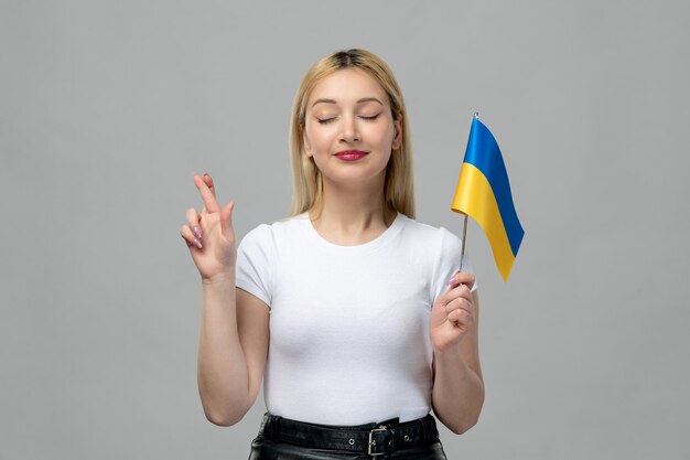 Ukraine russe conflit blonde jolie fille avec rouge à lèvres et drapeau ukrainien traversant les doigts