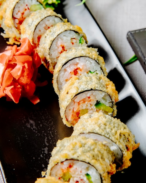 Photo gratuite unagi maki tempura concombre riz anguille fromage à la crème au gingembre vue latérale