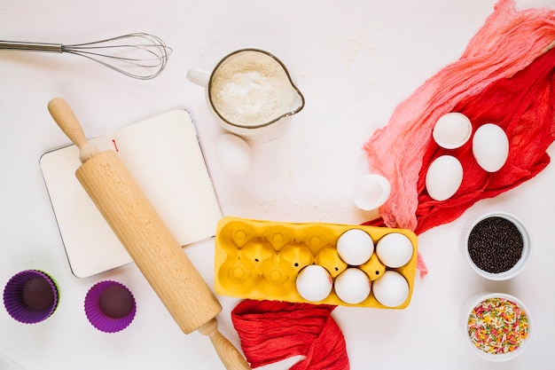 Photo gratuite ustensiles de cuisine à proximité du bloc-notes et des ingrédients