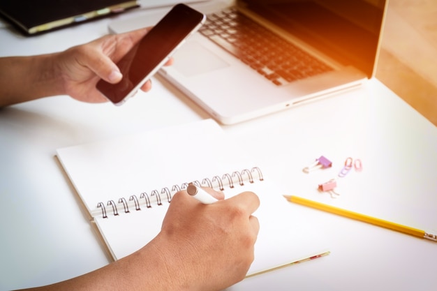 Utilisation de l&#39;homme d&#39;affaires sur un téléphone intelligent fonctionnant sur un rapport commercial. Mise au point sélective et filtre à flambeau doux