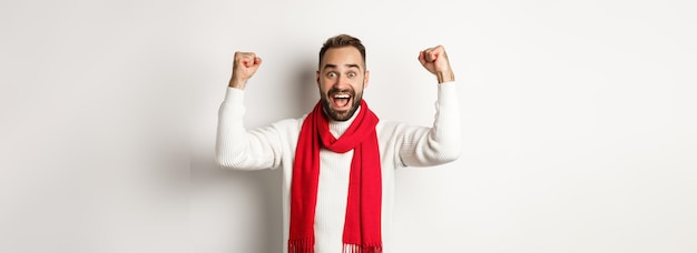 Photo gratuite vacances de noël et concept de nouvel an homme excité se réjouissant de gagner le prix levant les mains et loo