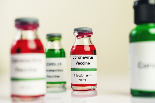 Le vaccin contre le covid-19 est en rouge et vert dans des bouteilles placées sur le sol.