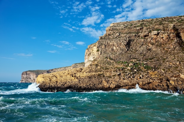 Photo gratuite vague de mer brisée contre la falaise de la côte