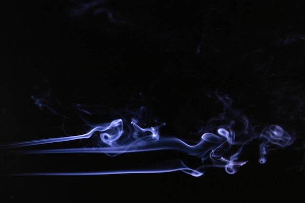 Photo gratuite vagues de fumée bleue sur fond noir