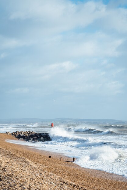 Vagues lavant la plage de sable par temps nuageux