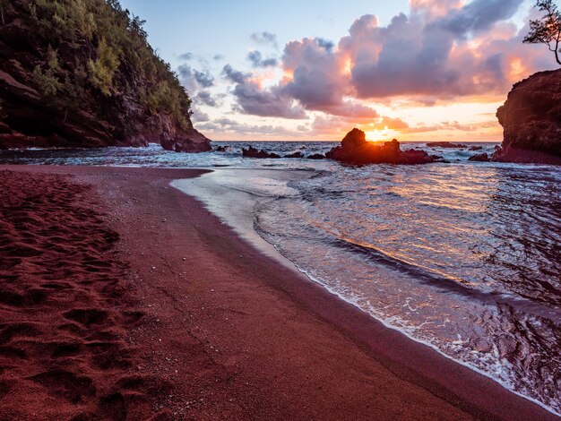 Vagues de la mer s'écrasant sur le rivage pendant le coucher du soleil