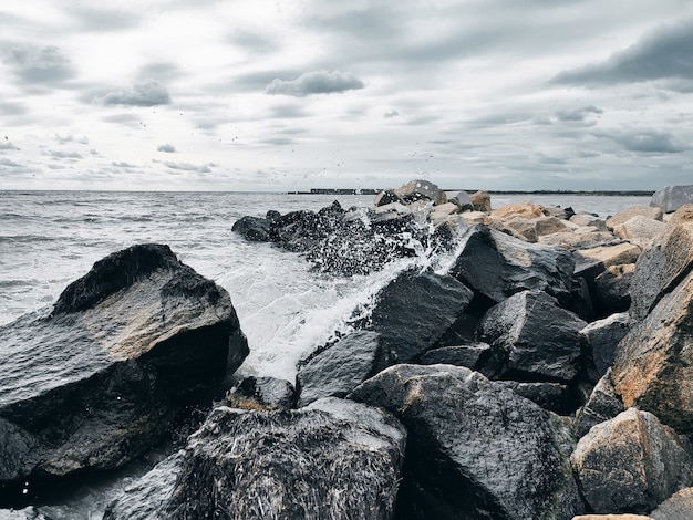Vagues de la mer se brisant sur les rochers avec des éclaboussures d'eau