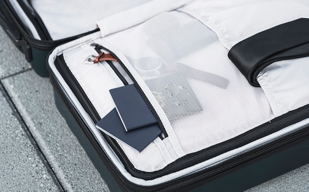 Valise ouverte avec montre passeport et cravate