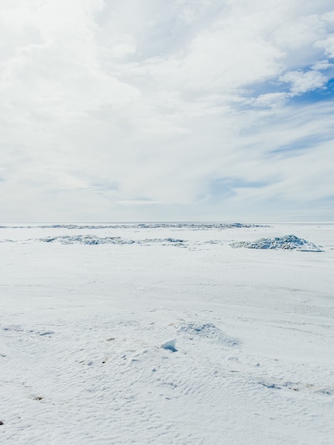 vallée recouverte de neige sur une froide journée d'hiver sous le ciel nuageux