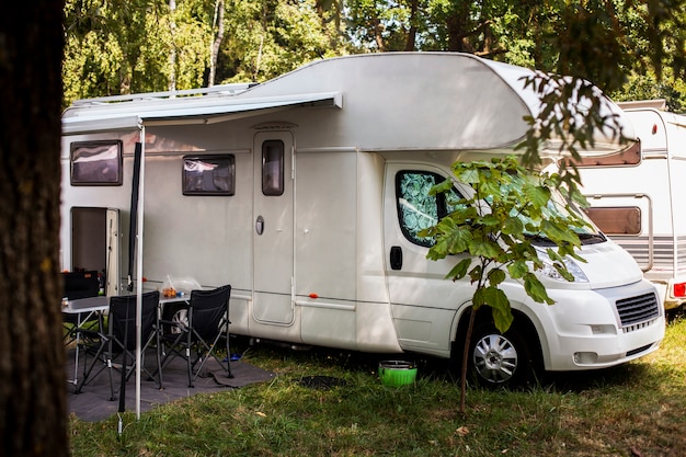 Van blanc avec table et chaises à côté