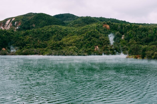 Vapeur sortant d'un beau plan d'eau entouré de montagnes verdoyantes