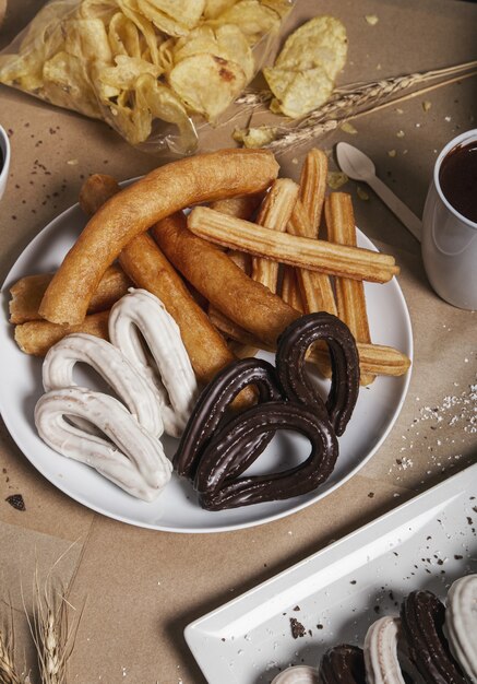 Variété de churros typiques sont servis à table pour le petit déjeuner.